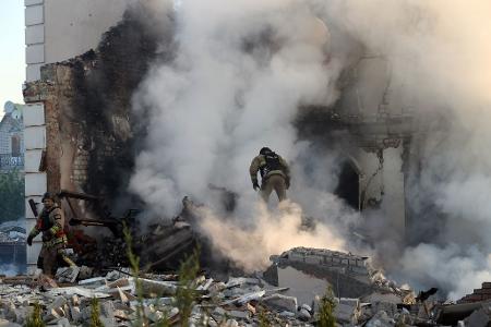 Nach russischen Beschuss steht ein Feuerwehrmann in Charkiw im Qualm eines brennenden Hauses. Russland setzt die Offensive im Grenzgebiet bei der Millionenstadt im Osten der Ukraine fort.