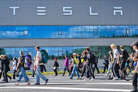 Teilnehmer einer Protestveranstaltung gehen zum Werk von Tesla in Grünheide in Brandenburg.